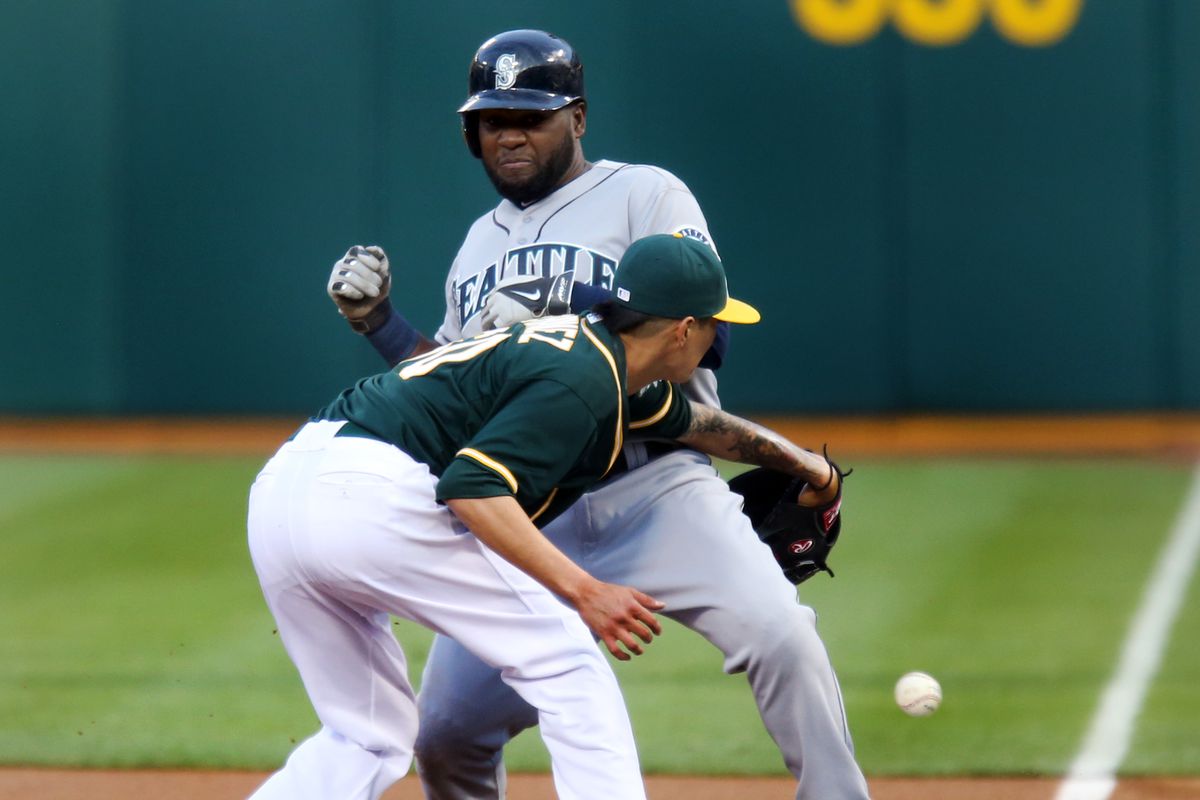 Oakland Athletics starting pitcher Jesse Chavez (60) fails to catch the throw at first base as Seattle Mariners’ Abraham Almonte (36) takes advantage of the error and runs to second in the first inning of their MLB game at O.co Coliseum in Oakland, Calif.