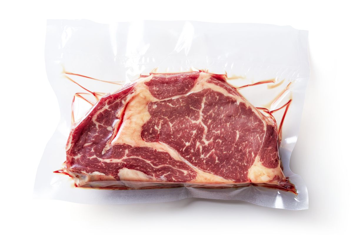 Raw steak in vacuum-sealed bag. 