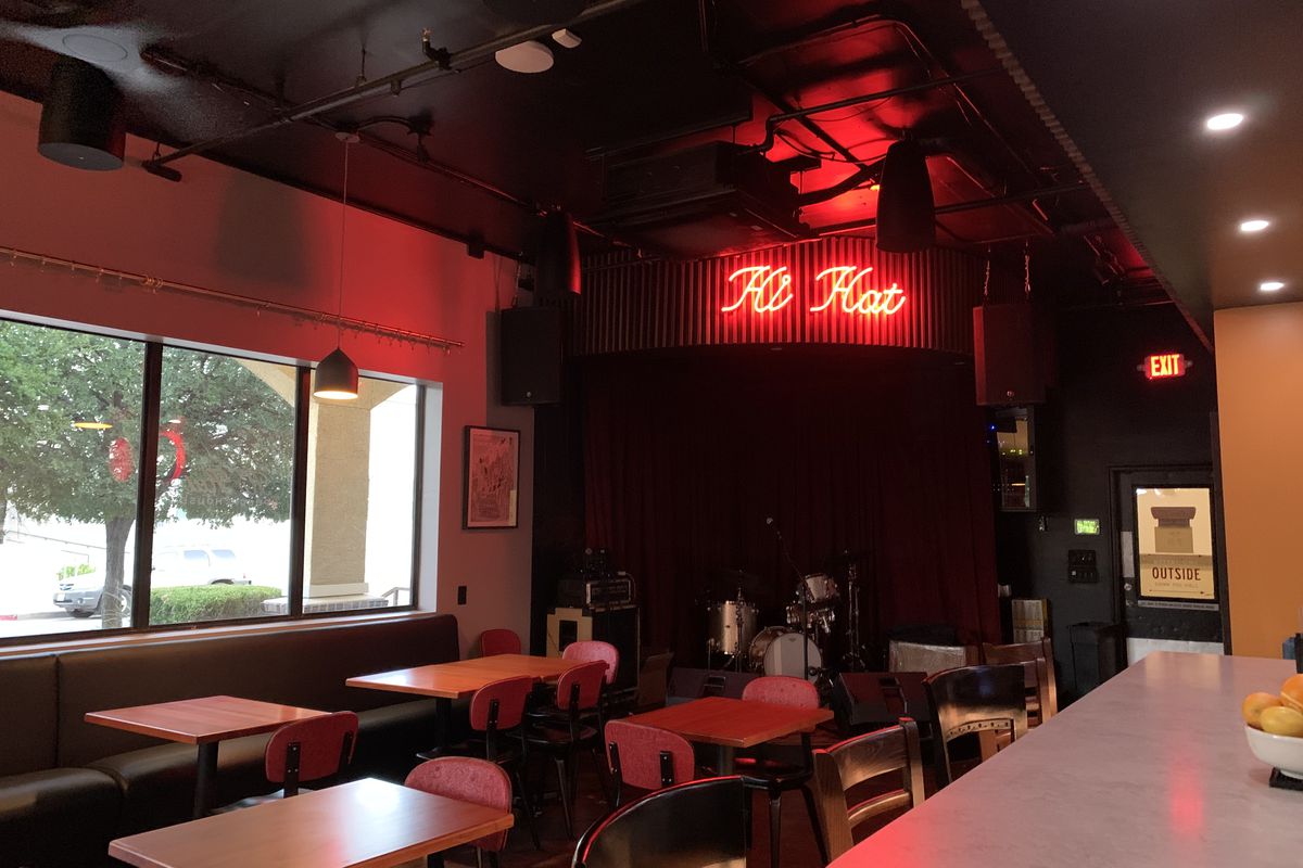 An indoor restaurant dining room with a red neon says that reads “Hi Hat.”