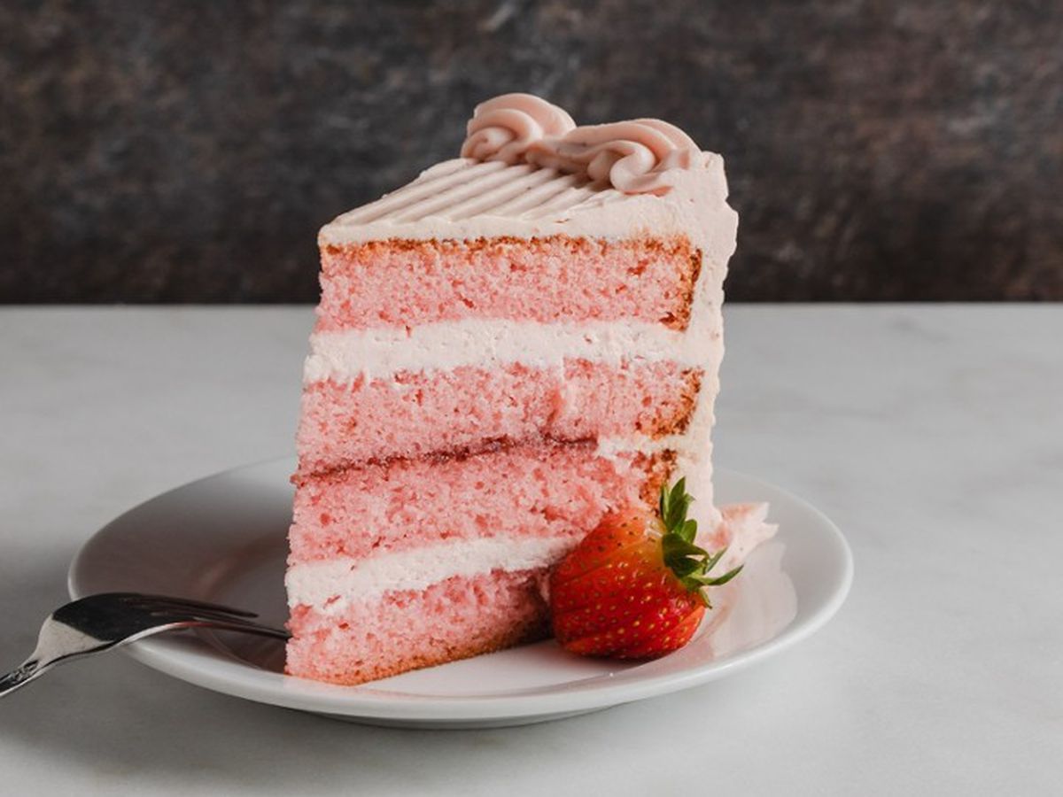 A slice of four layer strawberry cake.