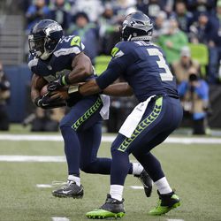 Seattle Seahawks quarterback Russell Wilson hands off to running back Robert Turbin, left, in the first half of an NFL football game against the St. Louis Rams, Sunday, Dec. 28, 2014, in Seattle.