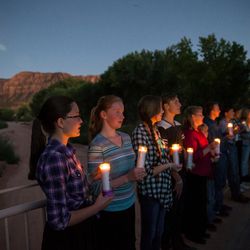 People carry candles representing each of the victims killed in last year's floods during a memorial ceremony at Cottonwood Park in Colorado City, Arizona, on Wednesday, Sept. 14, 2016.