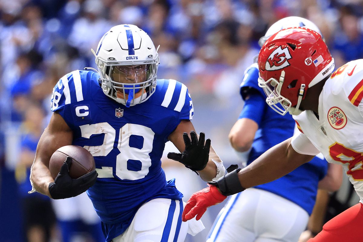 Jonathan Taylor #28 of the Indianapolis Colts runs with the ball against Carlos Dunlap #8 of the Kansas City Chiefs during the second half at Lucas Oil Stadium on September 25, 2022 in Indianapolis, Indiana.