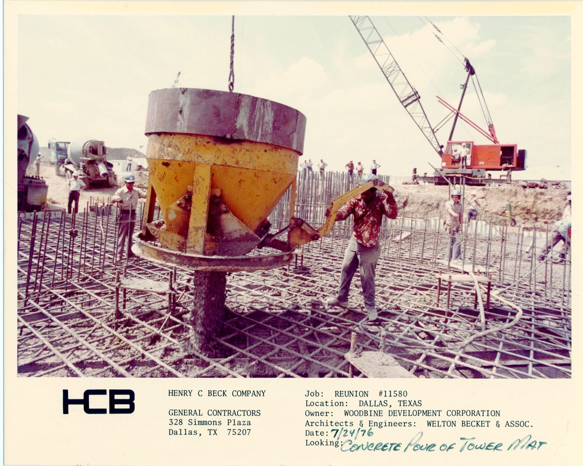 Construction workers handle equipment on a work site inside the steel rods forming a foundation in a photo from 1976.