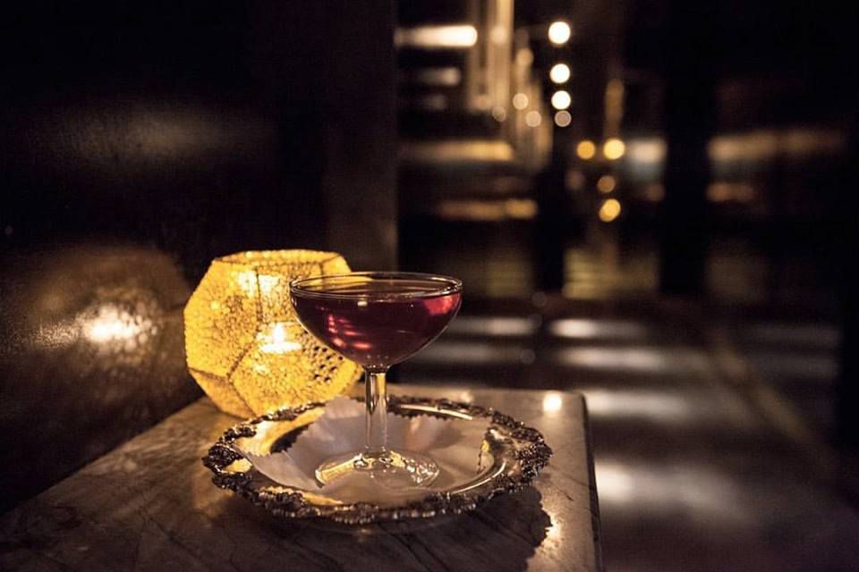 A dimly-lit cocktail drink on a table.