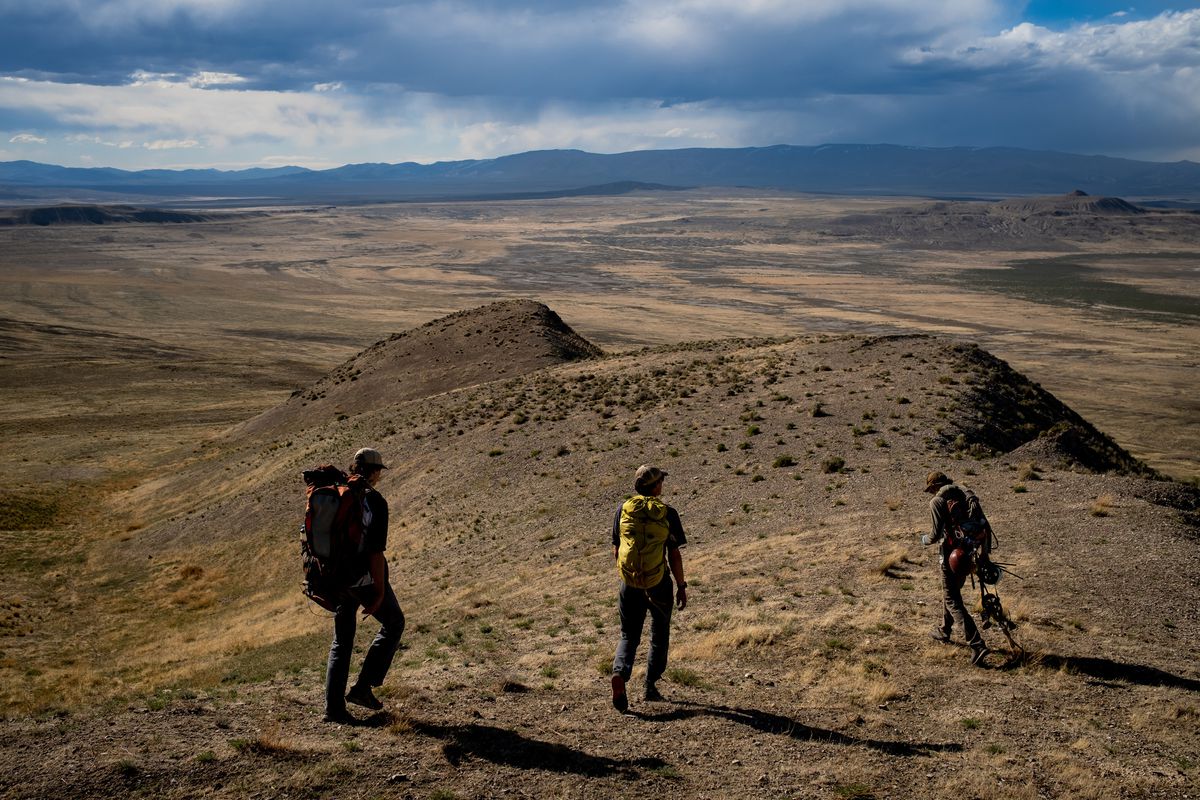 Hawkwatch International field biologists Max Carlin, left, and Jayden Skelly, center, and research associate Dustin Maloney walk back to their vehicle after entering a golden eagle nest in a remote area of Box Elder County on Wednesday, May 19, 2021.