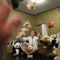 Cris Cyborg poses for pictures with the toys donated by fans for her charity toy drive at UFC 219 open workouts Thursday at T-Mobile Arena in Las Vegas.