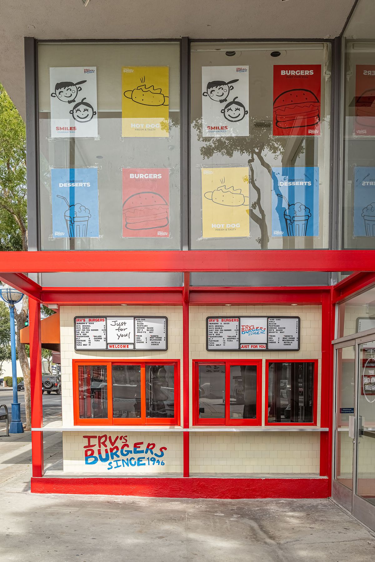 A face-on look at a walk-up restaurant with menus over the windows.