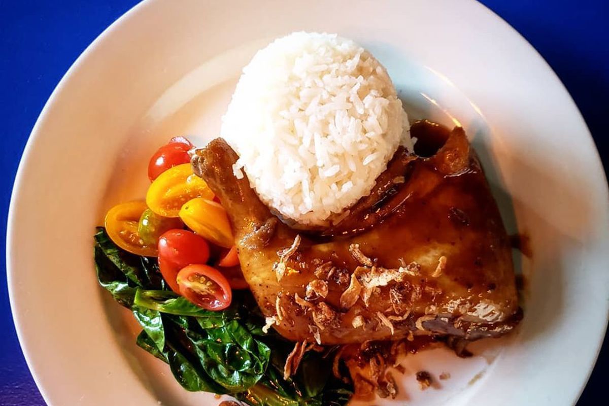 A Filipino chicken and rice dish on a white plate.