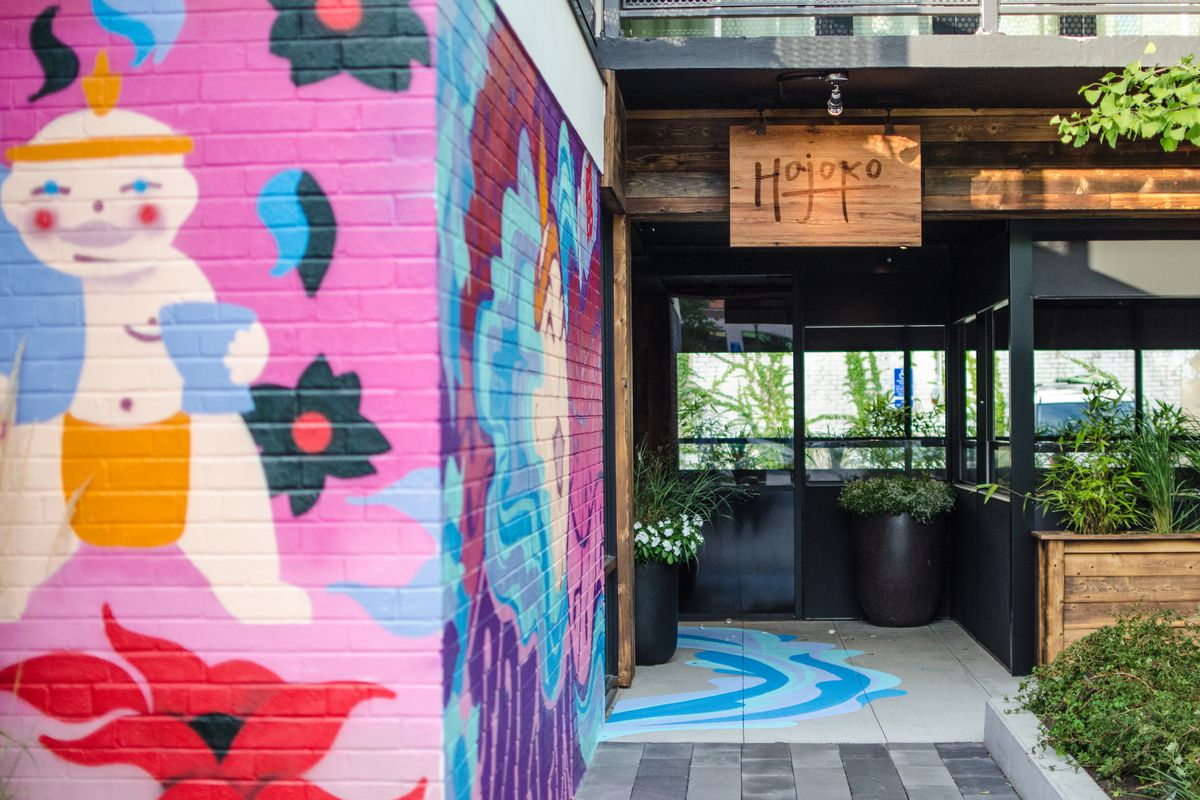 A colorful painted mural of a cartoonish sumo wrestler covers a brick wall leading towards the entrance of Hojoko in Boston’s Fenway neighborhood