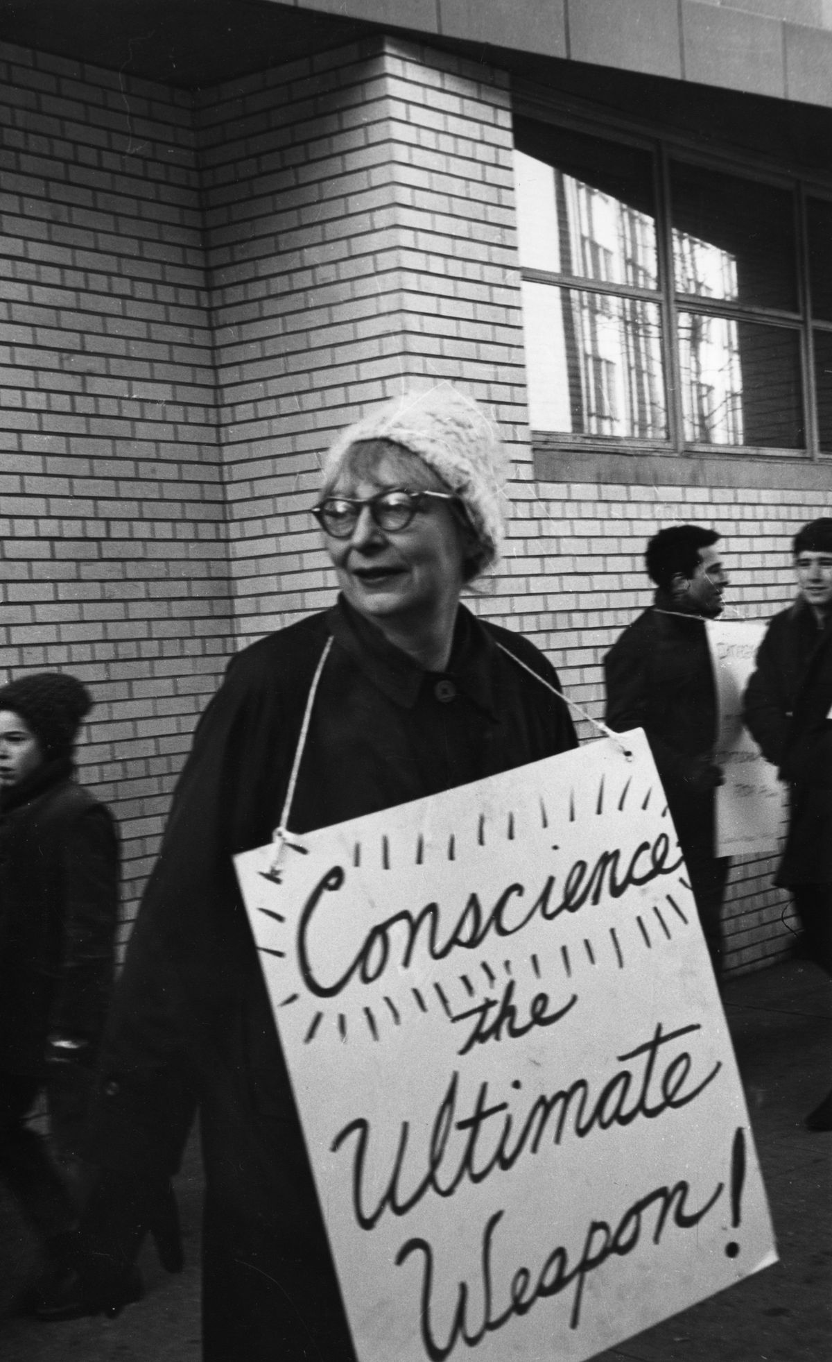 American-born Canadian social and urban activist & author Jane Jacobs (1916 - 2006), with a sign around her neck that reads 'Conscience is the Ultimate Weapon,' attends a boycott at Public School (P.S. 41) (at 116 West 11th Street), New York, New York, February 3, 1964. (Photo by Fred W. McDarrah/Getty Images) *** Local Caption *** Jane Jacobs