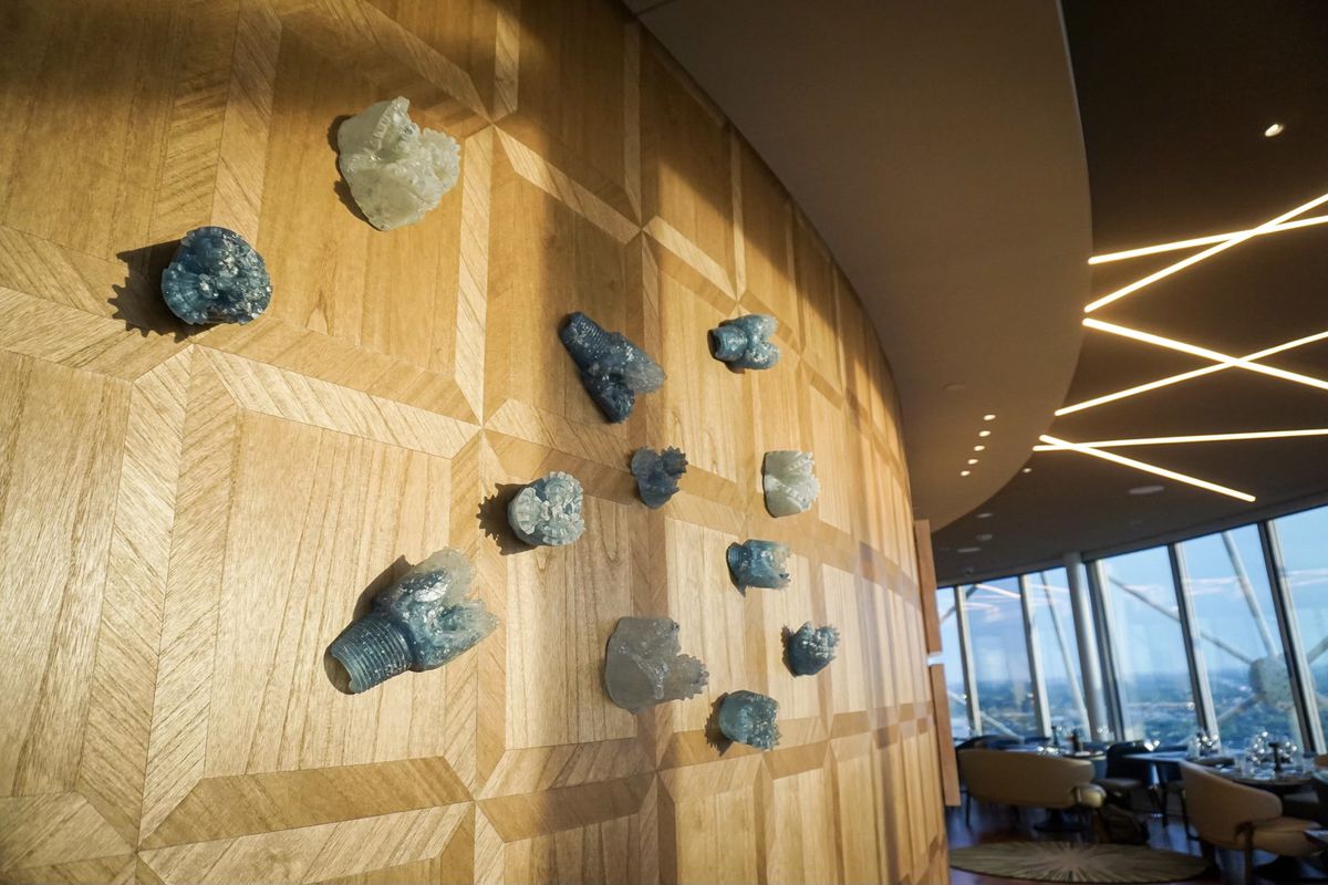 A wooden wall holds multiple resin-casted drill bits.