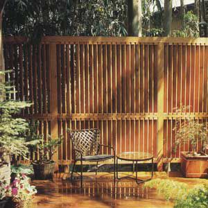 <p>A series of closely spaced 1x4 slats gives this intricate redwood fence the look of a partially open blind.</p>