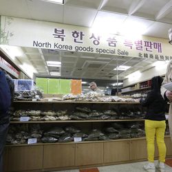 Visitors buy the North Korean goods at the Imjingak Pavilion near the border village of Panmunjom, which separates the two Koreas, in Paju, north of Seoul, South Korea, Sunday, April 14, 2013. As the world watches to see what North Korea's next move will be in a high-stakes game of brinksmanship with the United States, residents of its capital aren't hunkering down in bunkers and preparing for the worst. Instead, they are out on the streets en masse getting ready for the birthday of national founder Kim Il Sung — the biggest holiday of the year. 
