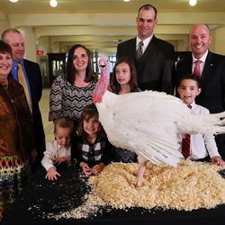 LuAnn Adams, Utah commissioner of Agriculture and Food, left, Matt Cook, president and CEO of Norbest, the Jason Christensen family and Lt. Gov. Spencer Cox pose with Sir Featherbottoms after Cox pardoned the turkey during a ceremony at the Capitol in Salt Lake City on Monday, Nov. 21, 2016.
