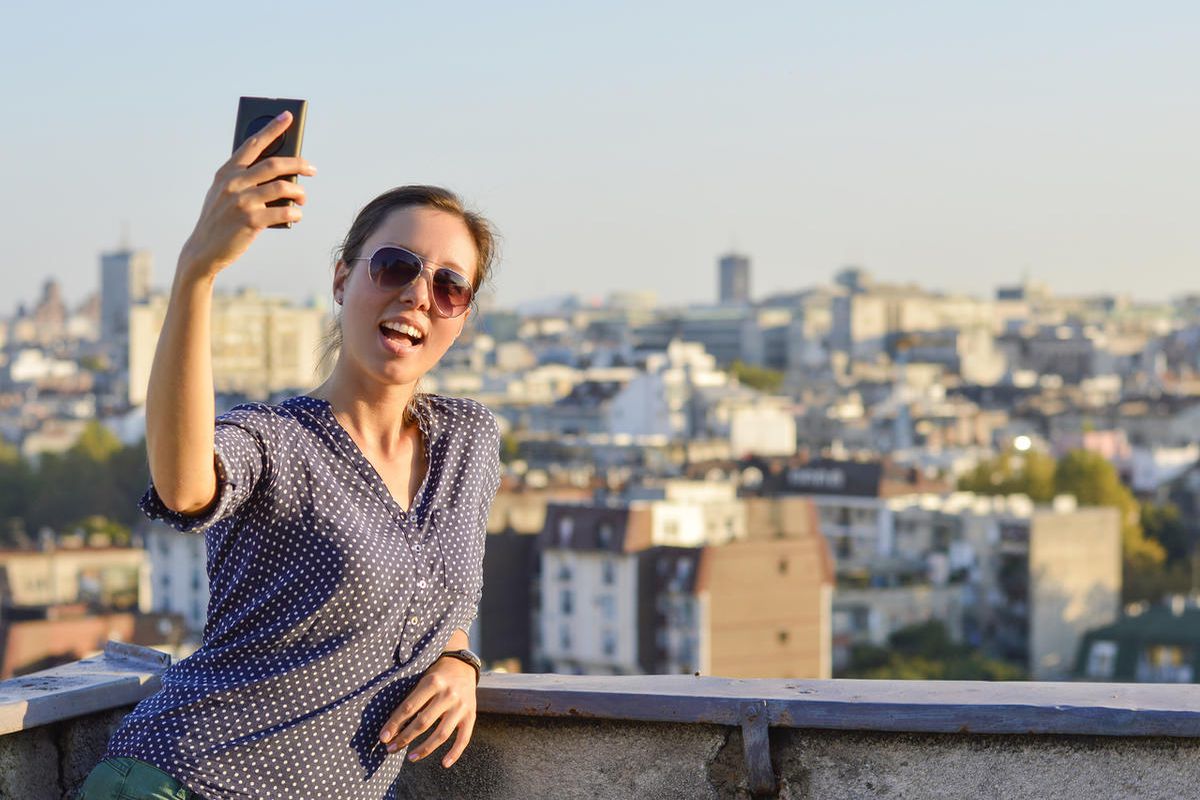 Girl taking a selfie at the rooftop with view at city of Belgrade