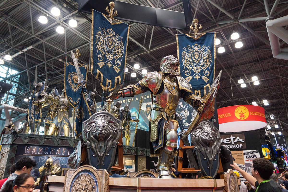 a life-size model of an Alliance soldier from the movie Warcraft, with Alliance banners and shields around him, at the Weta Workshop booth at NYCC 2015