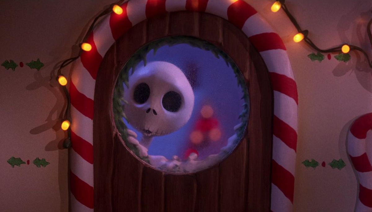 Jack Skellington peering through the circular window of a wooden door framed by candy canes and festive lights in The Nightmare Before Christmas.