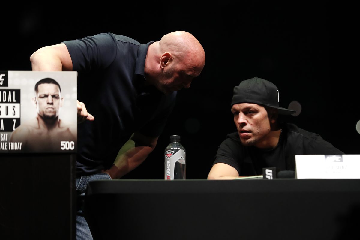 Dana White whispers to Nate Diaz during a UFC press conference.
