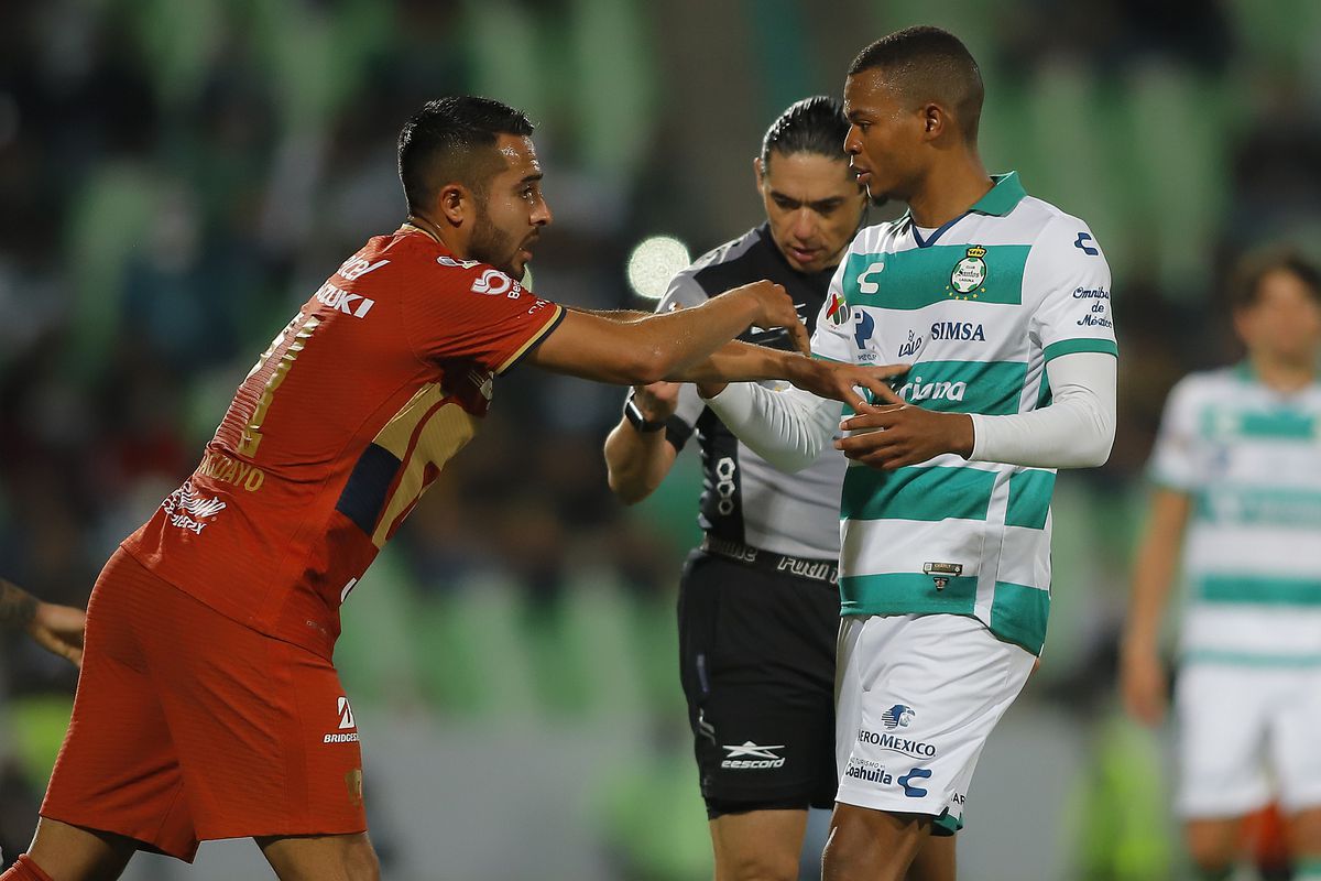 Juan Aguayo of Pumas (L) fights with Harold Preciado of Santos during the 8th round match between Santos Laguna and Pumas UNAM as part of the Torneo Grita Mexico C22 Liga MX at Corona Stadium on March 2, 2022 in Torreon, Mexico.
