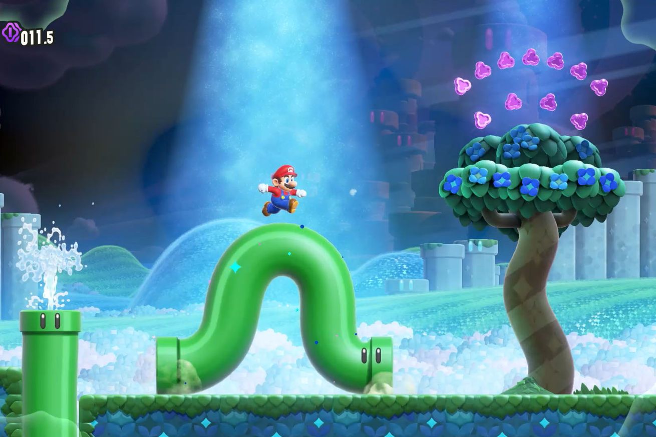 A screenshot from the video game Super Mario Bros. Wonder in which Mario stands on a wiggling green pipe in a surreal fantasy world.