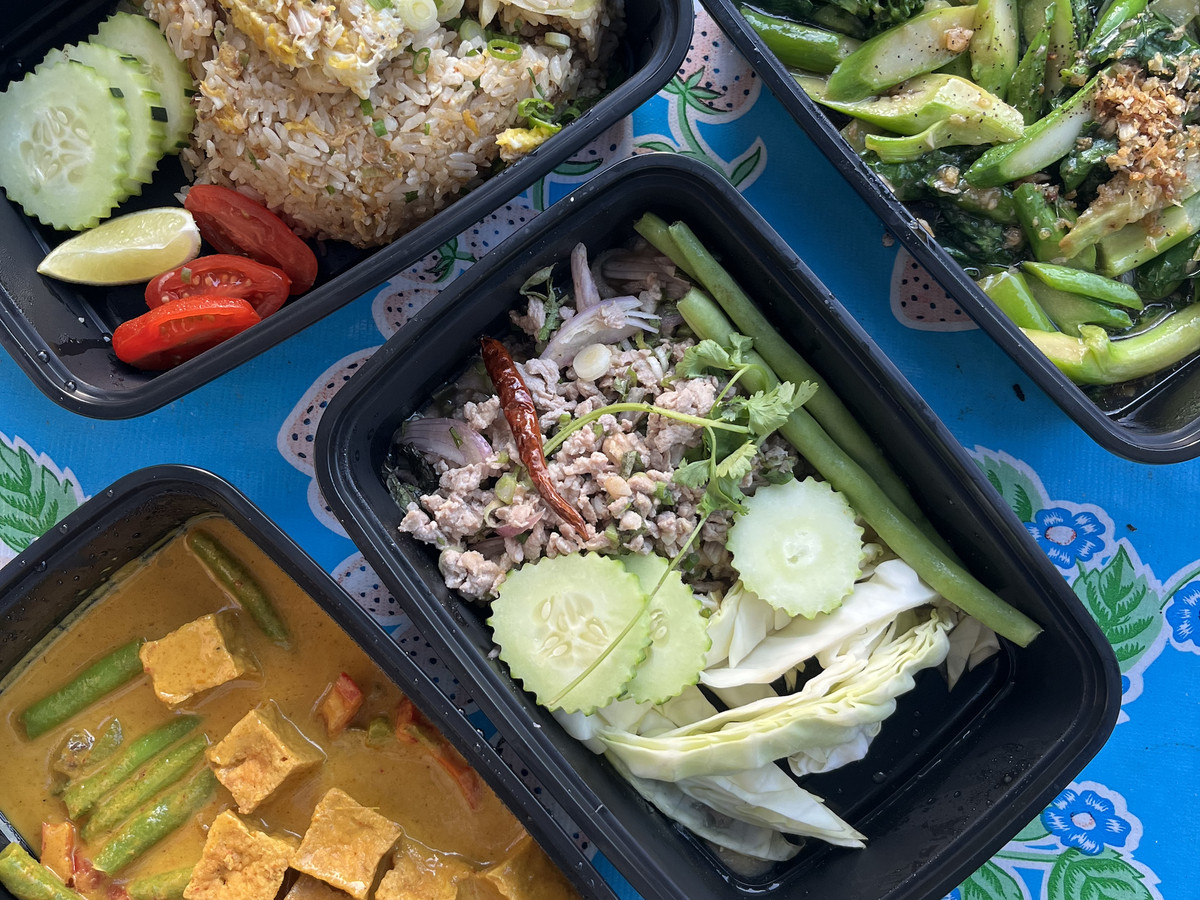 A selection of Thai dishes in take-out containers.