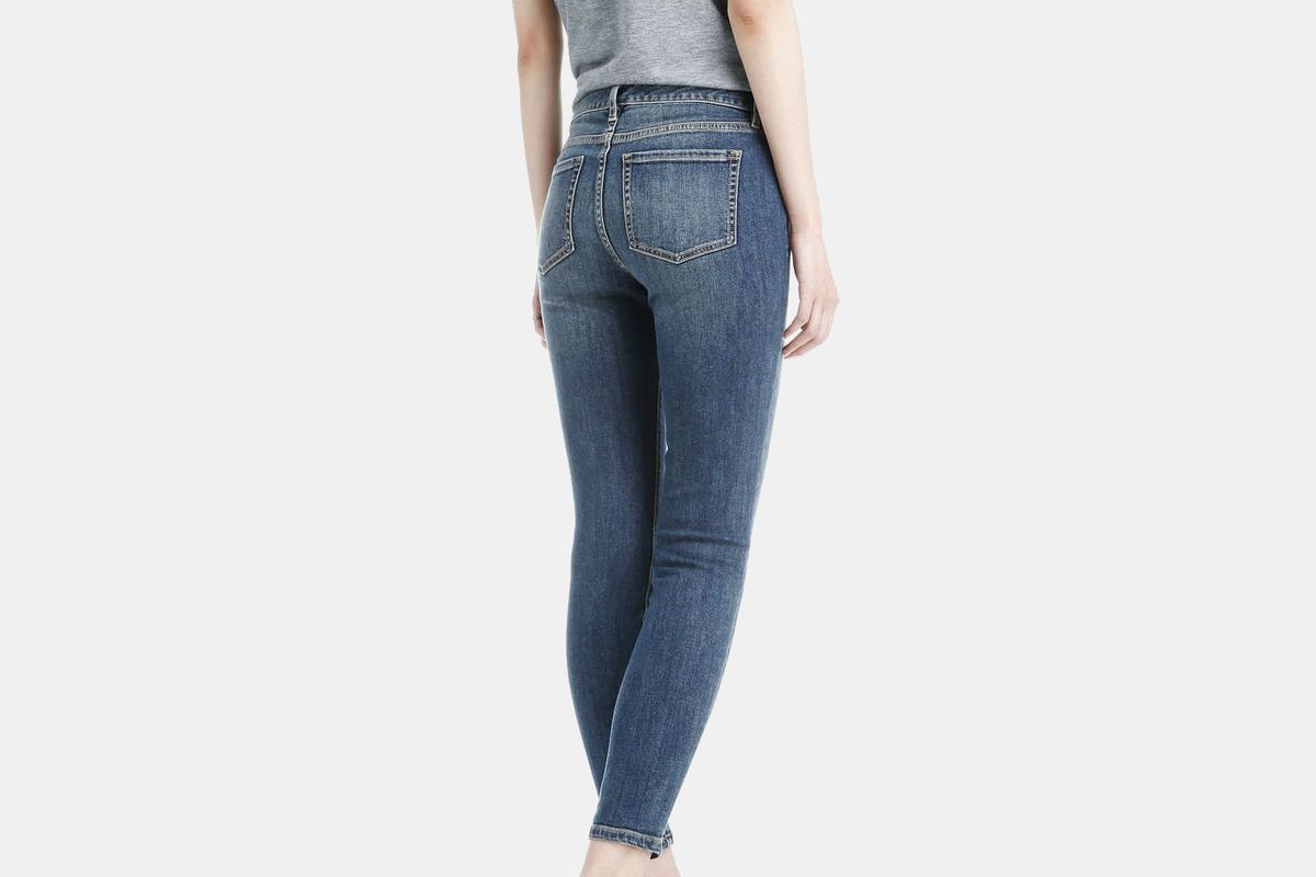 A woman shown from the waist down wearing a pair of slim-fitting jeans