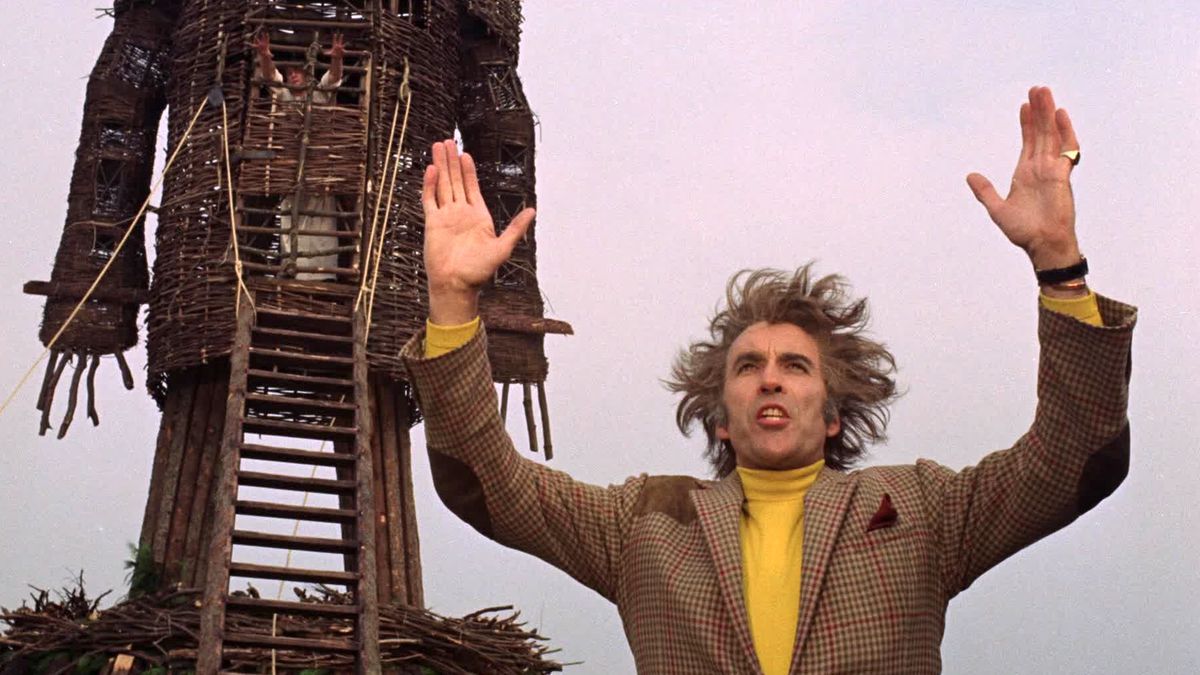 Lord Summerisle holds two hands in the air as he preaches to the crowd and prepares light the wicker man and Sgt. Neil Howie aflame