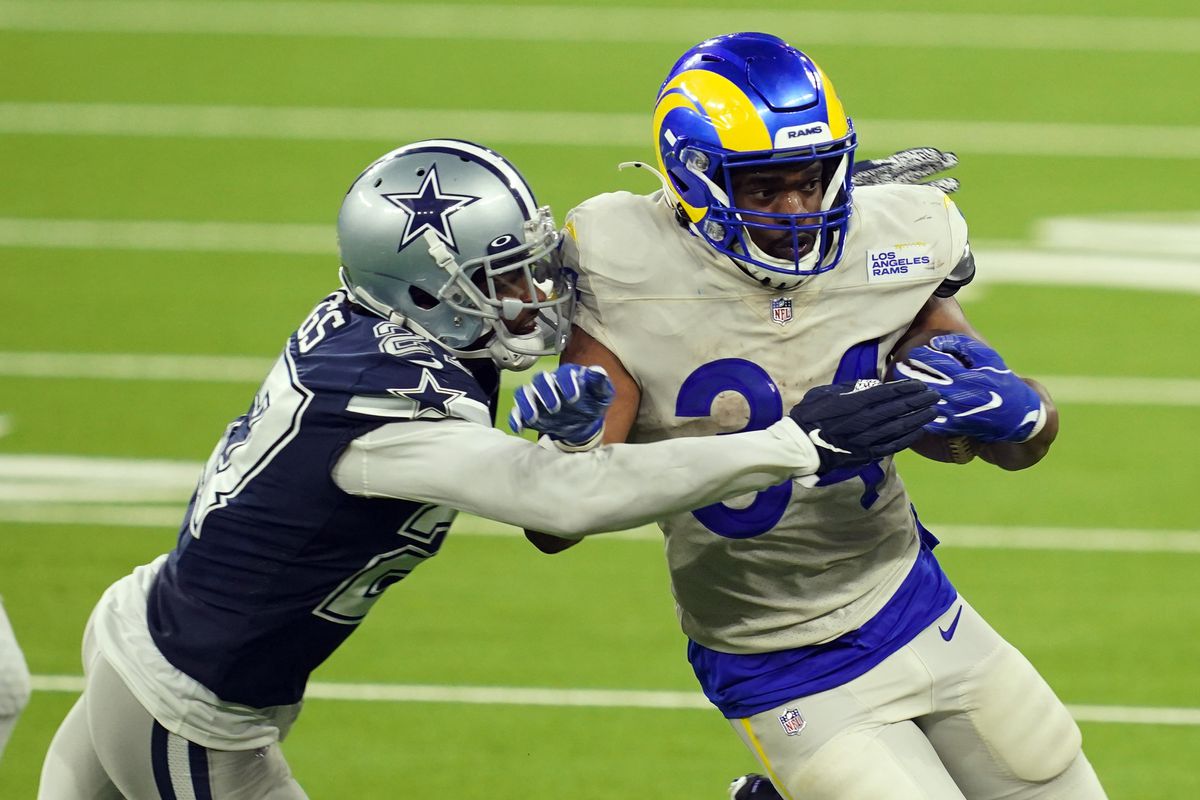 Los Angeles Rams running back Malcolm Brown is defended by Dallas Cowboys cornerback Trevon Diggs in the fourth quarter at SoFi Stadium. The Rams defeated the Cowoboys 20-17