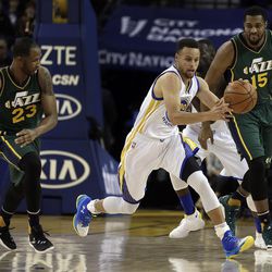 Golden State Warriors' Stephen Curry, center, drives the ball between Utah Jazz's Chris Johnson (23) and Derrick Favors (15) during the first half of an NBA basketball game Wednesday, March 9, 2016, in Oakland, Calif. (AP Photo/Ben Margot)