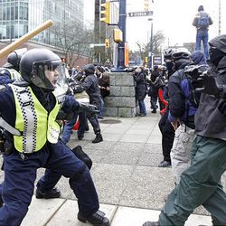A policeman wields a baton at a protester in downtown Vancouver, British Columbia during the second day of the 2010 Vancouver Olympic Winter Games, Saturday.