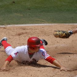 Los Angeles Angels' J.B. Shuck, left scores on a fielders choice by Mike Trout as Pittsburgh Pirates catcher Michael McKenry makes a late tag during the second inning of their baseball game, Sunday, June 23, 2013, in Anaheim, Calif.  