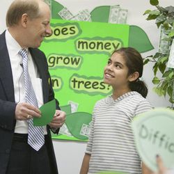Karen Trujillo smiles up at Zions Bancorporation Chairman, President and CEO Harris Simmons Monday, April 22, 2013, during a money-saving program at Guadalupe School in Salt Lake City in honor of National Teach Children to Save Day.