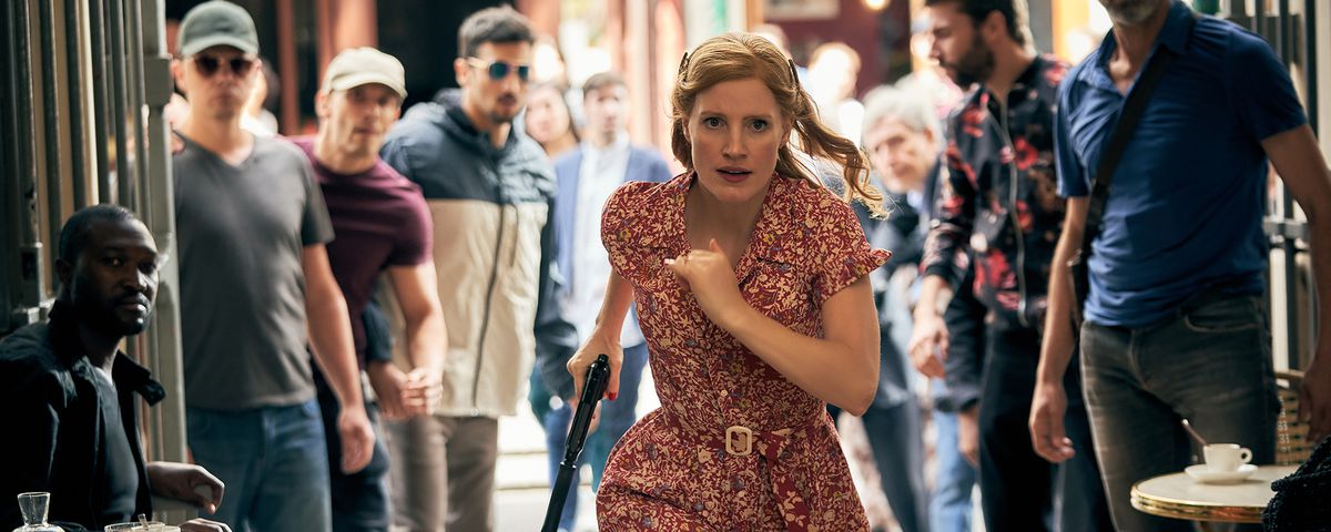 Jessica Chastain charges at the camera as a crowd of men gawp in The 355