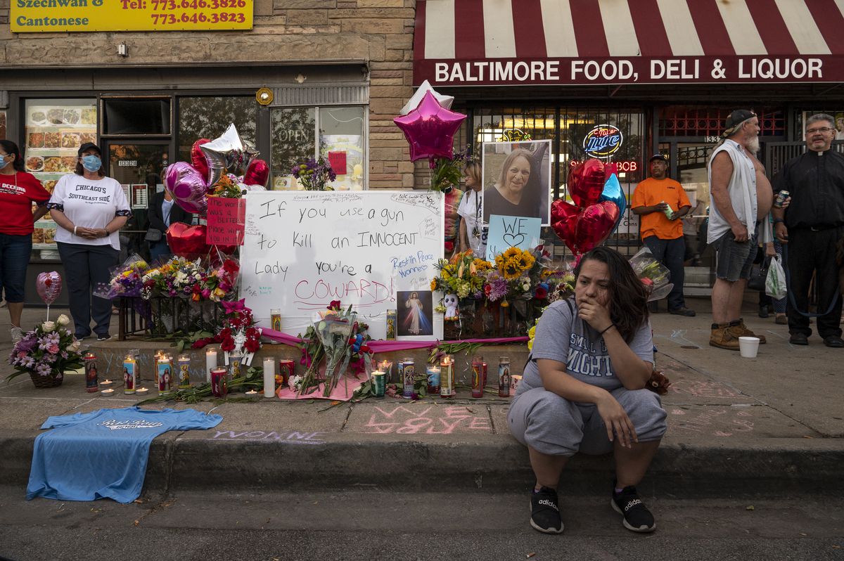 A woman sits in front of a memorial set up for Yvonne Ruzich outside Baltimore Food &amp; Liquor Store in the Hegewisch neighborhood, Monday, Aug. 16, 2021.