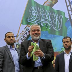 In this Dec. 12, 2014 file photo, top Palestinian Hamas leader Ismail Haniyeh holds a dove sprayed green, the color of Hamas, before he releases it during a rally to commemorate the 27th anniversary of the Hamas militant group, at the main road in Jebaliya, the northern Gaza Strip. An Egyptian court declared Hamas a "terrorist organization" on Saturday, Feb. 28, 2015, further isolating the rulers of the Gaza Strip who once found a warm welcome under the country's past Islamist government.