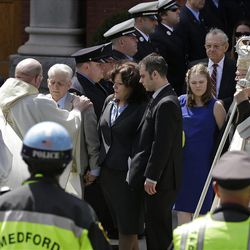 A priest comforts family members of Boston Marathon bomb victim Krystle Campbell after her funeral at St. Joseph's Church in Medford, Mass. Monday, April 22, 2013. At center is her mother, Patty Campbell, and her brother, Billy. At far right is Boston Cardinal Sean O'Malley. (AP Photo/Elise Amendola)