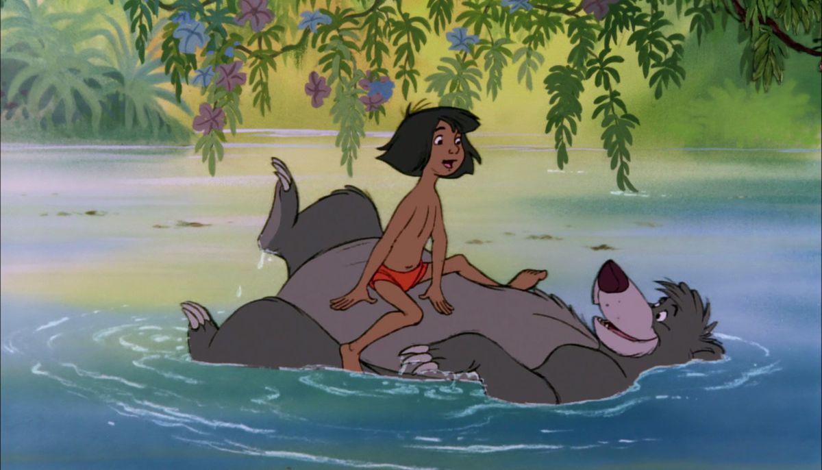 Mowgli sits on Baloo’s stomach as the bear floats down a river and they sing together in The Jungle Book