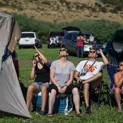 Xelli Berg 11, Leslie Jones, TQ Berg and Decca Berg, 9, of Seattle, watch the early stages of the total solar eclipse at Mann Creek Reservoir near Weiser, Idaho, on Monday, Aug. 21, 2017.