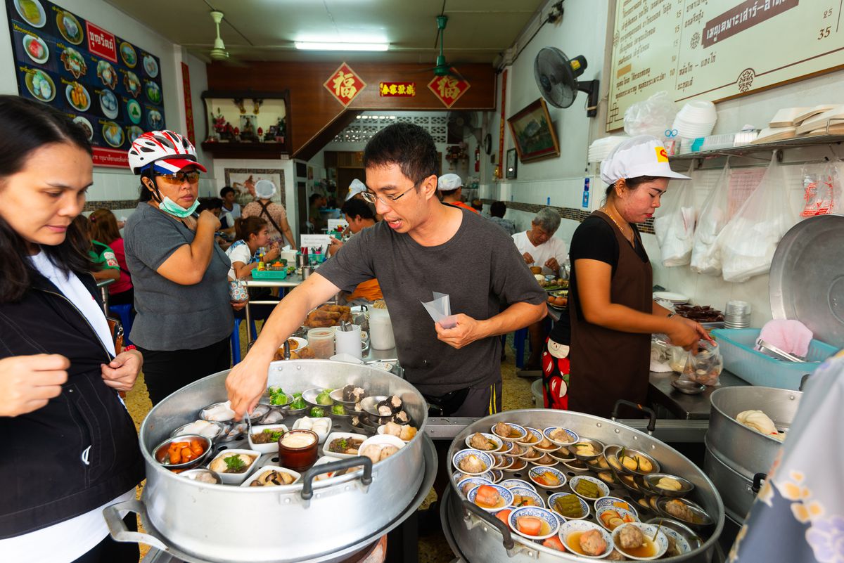 Servers collect orders and dole out items in a busy dim sum restaurant.