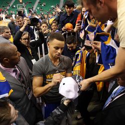 Fans lean over a railing to get an autograph from Golden State Warriors guard Stephen Curry, center, before an NBA regular season game against the Utah Jazz at the Vivint Arena in Salt Lake City, Wednesday, March 30, 2016.