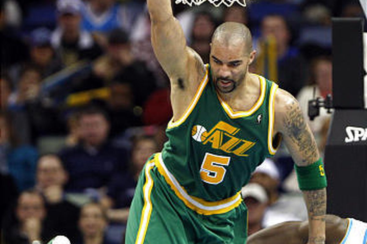 Jazz forward Carlos Boozer (5) hangs onto the rim after throwing down a dunk.  