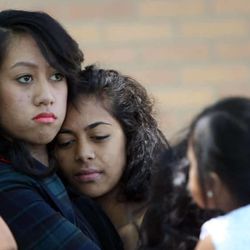 Two young women embrace after the funeral of Siosiua Andrew Taufa at the LDS Church in West Valley City on June 28, 2013.