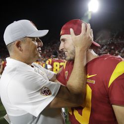Southern California coach Clay Helton, left, hugs quarterback Matt Fink after the team’s 30-23 win over Utah in an NCAA college football game Friday, Sept. 20, 2019, in Los Angeles
