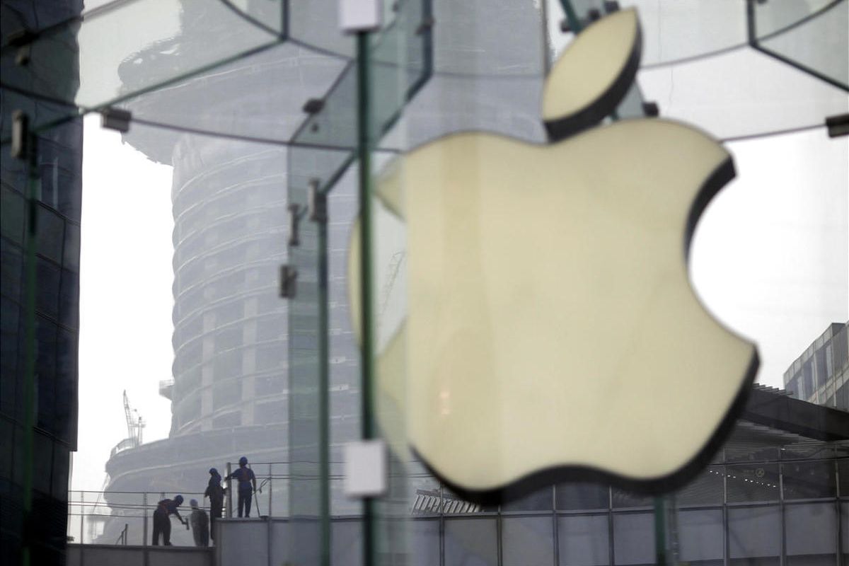 FILE - In this Friday, July 20, 2012 file photo, workers clean the rooftop of a building near an Apple Store in Shanghai, China. Apple was one of the star performers of the first quarter of 2012 and was probably the year's most talked-about company. The p
