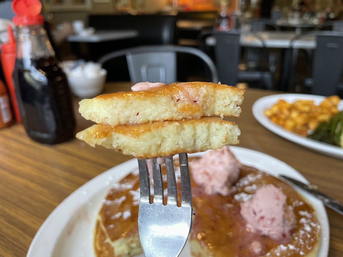 A fork stabbing two slices of pancake.