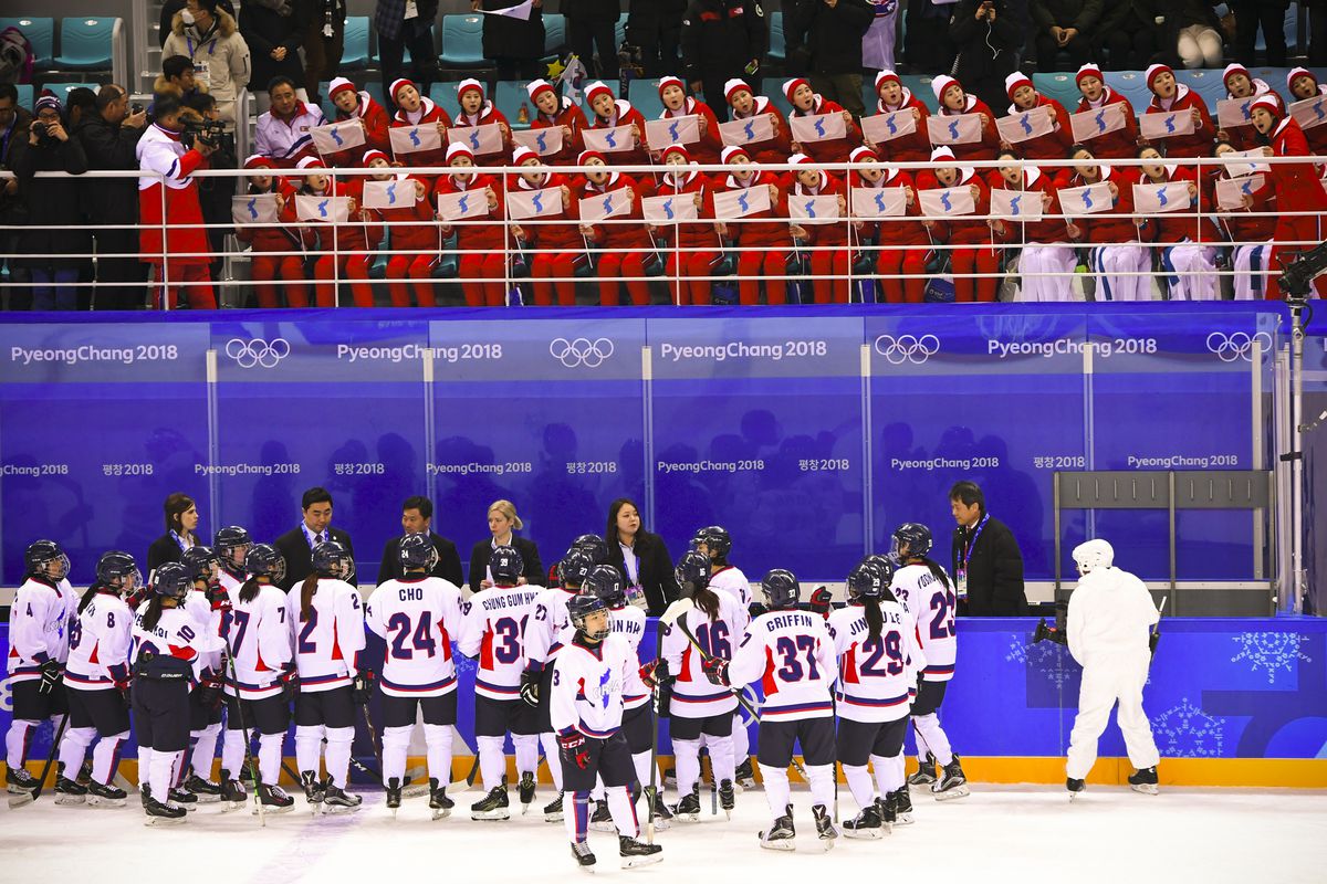 North Korea's cheerleaders hold the Unified Korea flag and cheer after the women's preliminary round ice hockey match between Switzerland and the Unified Korean team.
