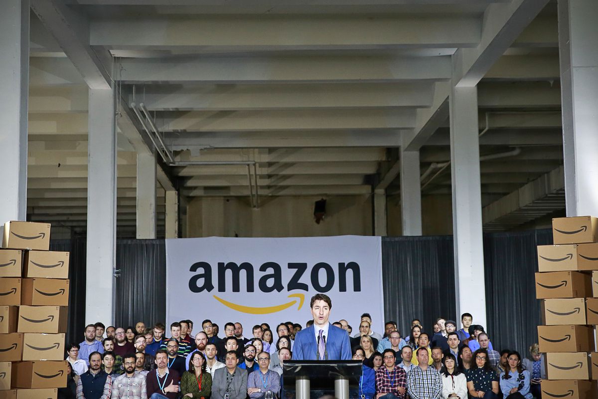 Canadian Prime Minister Justin Trudeau standing at a podium in front of an Amazon banner and a crowd of people while announcing a new tech hub in Vancouver.
