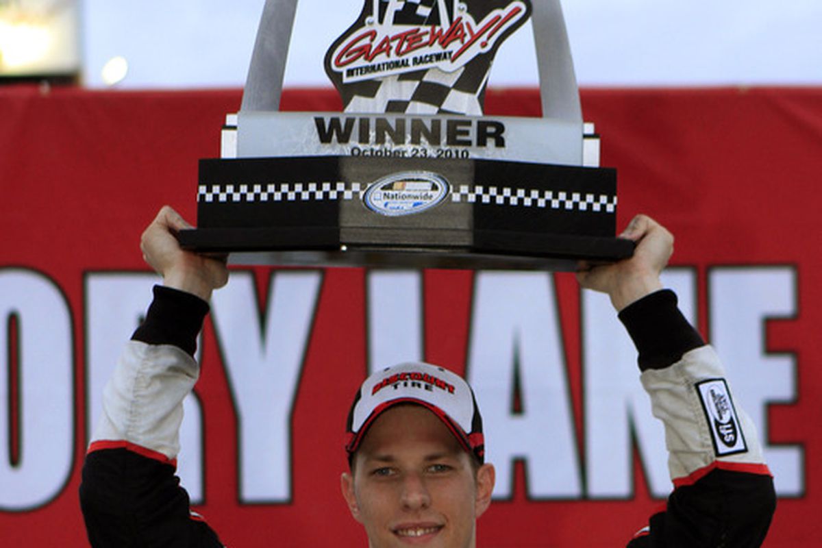 Brad Keselowski holds up the trophy after winning the NASCAR 5-hour Energy 250 at Gateway International Raceway on Oct. 23.