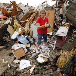JoAnn Anderson sorts through the rubble of her home after a tornado on Monday, May 20, 2013  in Moore, Okla. A monstrous tornado roared through the Oklahoma City suburbs, flattening entire neighborhoods with winds up to 200 mph, setting buildings on fire and landing a direct blow on an elementary school.